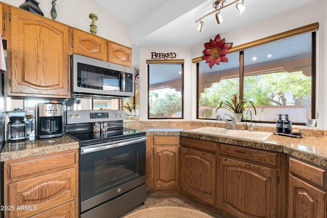 kitchen featuring a sink, appliances with stainless steel finishes, tile counters, and vaulted ceiling