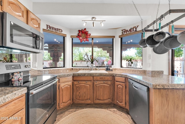 kitchen featuring a sink, brown cabinets, appliances with stainless steel finishes, and tile countertops