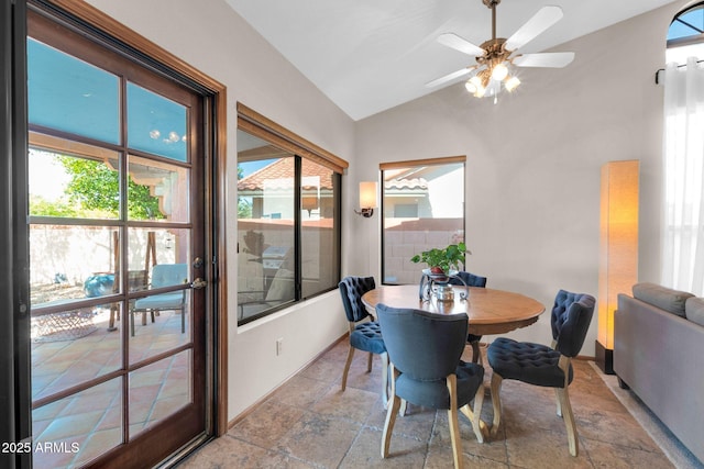 dining room featuring ceiling fan, lofted ceiling, and stone tile flooring