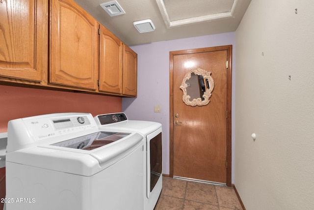 clothes washing area with visible vents, cabinet space, baseboards, and washing machine and clothes dryer