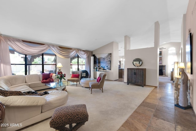 living room featuring lofted ceiling and stone tile flooring