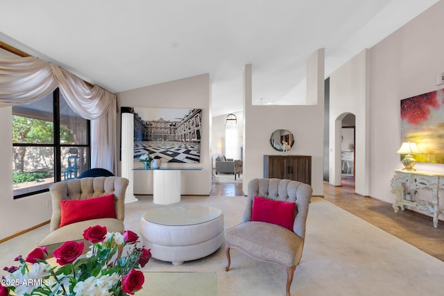 living area with arched walkways and vaulted ceiling