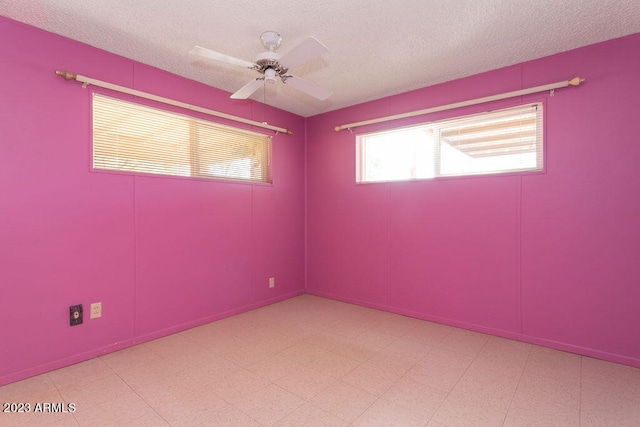 empty room featuring ceiling fan, a textured ceiling, and light tile flooring