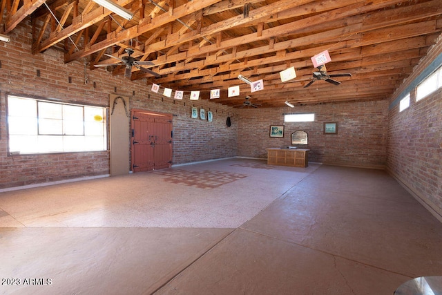 interior space with brick wall and ceiling fan