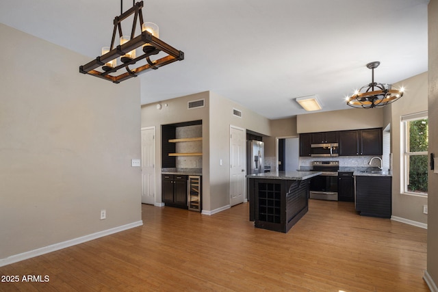 4753 E Bighorn Ave, Phoenix, AZ 85044 - kitchen featuring a chandelier, appliances with stainless steel finishes, decorative backsplash, a sink, and a center island