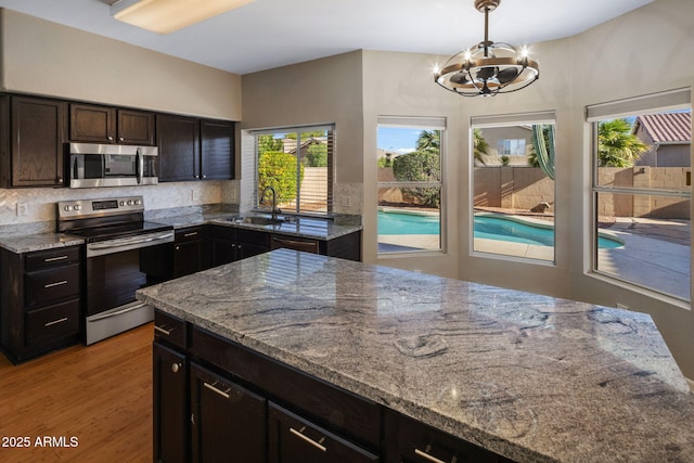 4753 E Bighorn Ave, Phoenix, AZ 85044 - kitchen featuring appliances with stainless steel finishes, a chandelier, plenty of natural light, and light stone counters