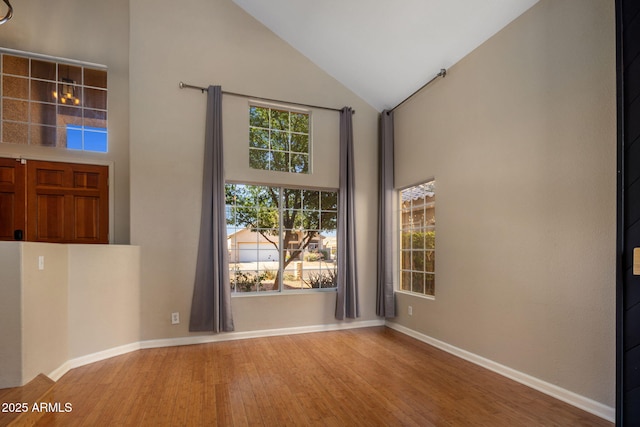 4753 E Bighorn Ave, Phoenix, AZ 85044 - unfurnished room featuring high vaulted ceiling, wood finished floors, and baseboards