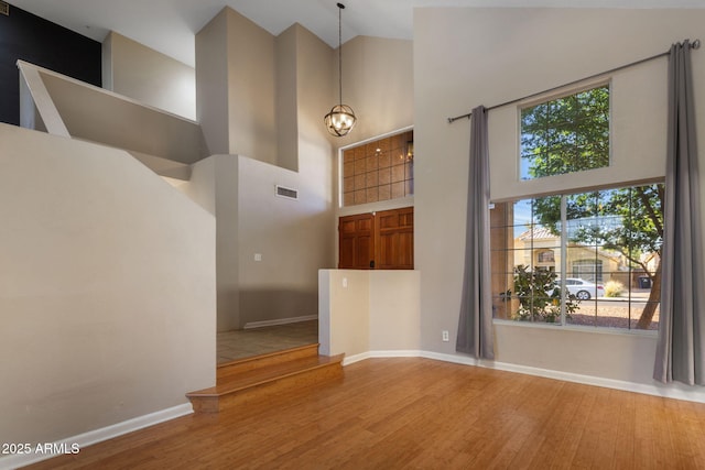 4753 E Bighorn Ave, Phoenix, AZ 85044 - foyer with high vaulted ceiling, wood finished floors, a chandelier, and baseboards