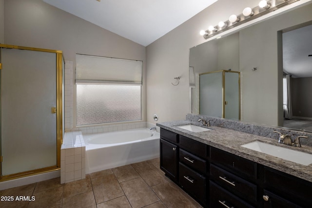 4753 E Bighorn Ave, Phoenix, AZ 85044 - full bathroom with vaulted ceiling, a shower stall, a garden tub, double vanity, and tile patterned flooring