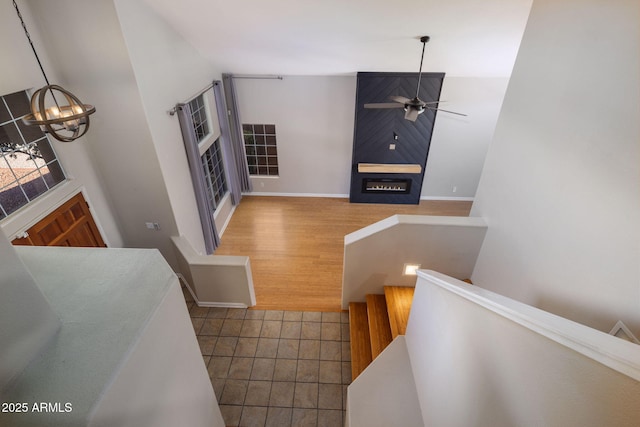 4753 E Bighorn Ave, Phoenix, AZ 85044 - staircase featuring a chandelier, a ceiling fan, a fireplace, and baseboards