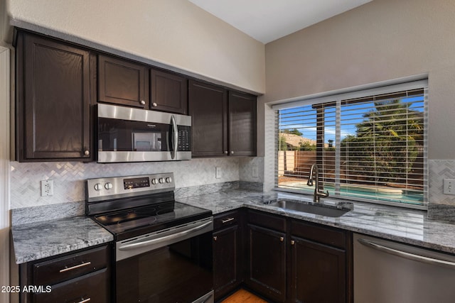 4753 E Bighorn Ave, Phoenix, AZ 85044 - kitchen featuring stainless steel appliances, a sink, backsplash, light stone counters, and dark brown cabinetry