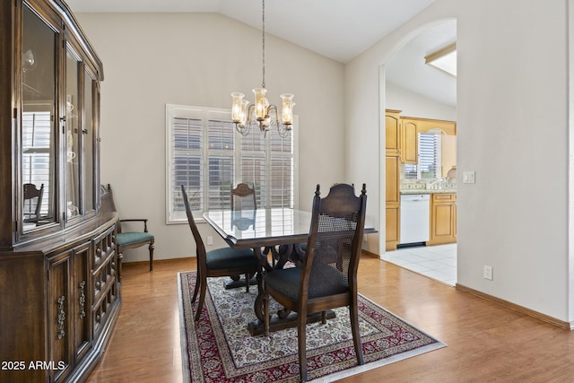 8431 W Utopia Rd, Peoria, AZ 85382 - dining area featuring lofted ceiling, arched walkways, a chandelier, and light wood finished floors