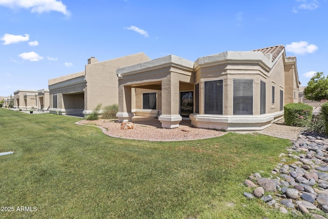 8431 W Utopia Rd, Peoria, AZ 85382 - back of house featuring a yard, stucco siding, and a chimney