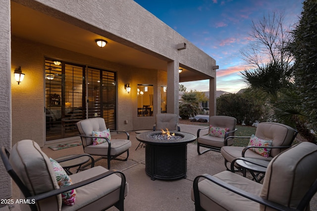 patio terrace at dusk featuring an outdoor living space with a fire pit