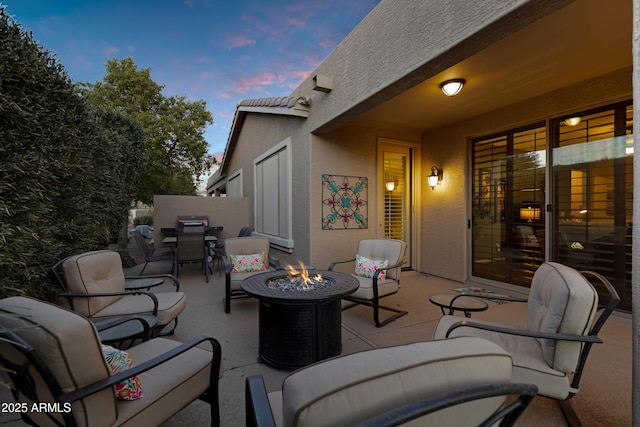 patio terrace at dusk featuring an outdoor fire pit