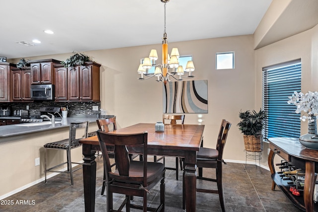 dining area with sink and a chandelier