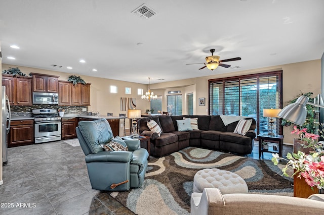 living room with ceiling fan with notable chandelier