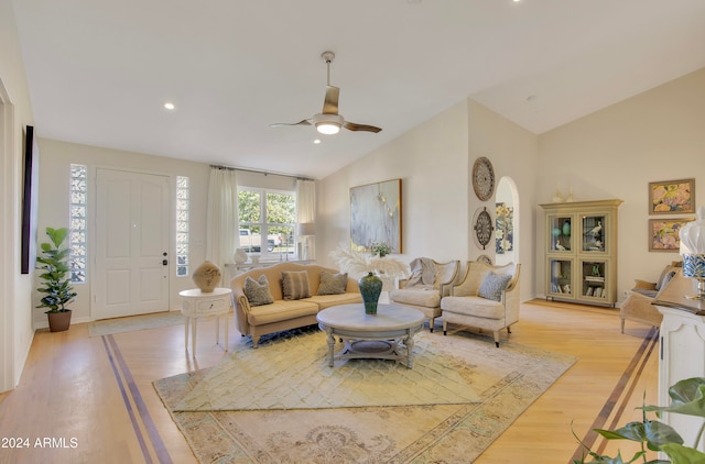 living room with light hardwood / wood-style flooring, lofted ceiling, and ceiling fan