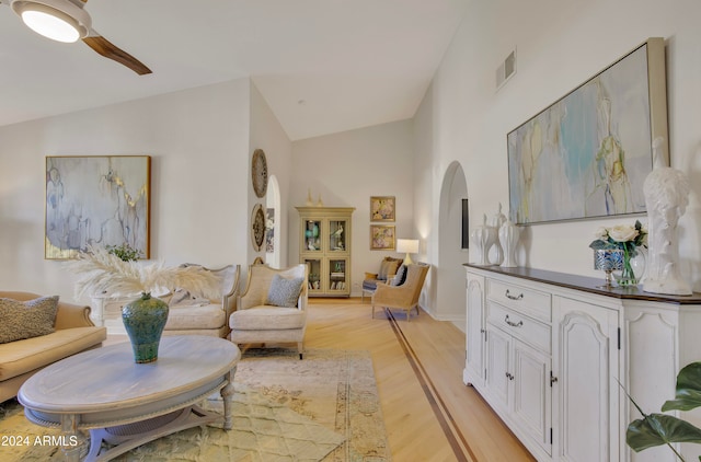 living room featuring vaulted ceiling, light wood-type flooring, and ceiling fan