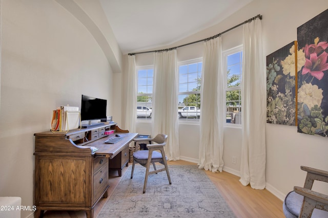 home office featuring vaulted ceiling and light hardwood / wood-style floors