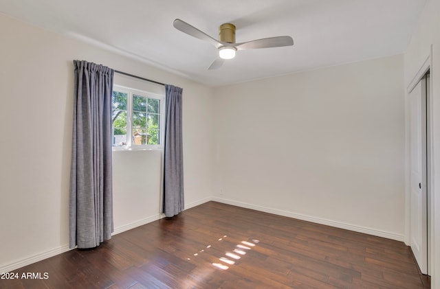 spare room with dark hardwood / wood-style floors and ceiling fan