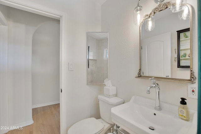 bathroom with toilet, hardwood / wood-style floors, and sink