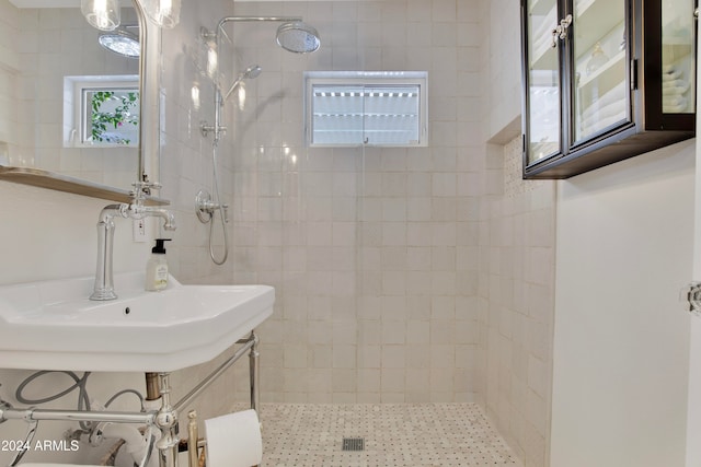 bathroom with tiled shower and sink