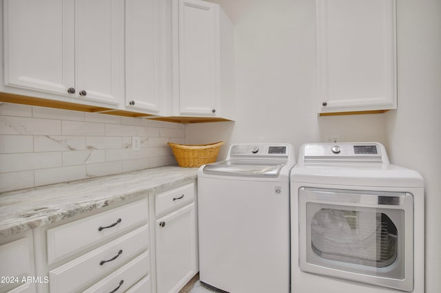 washroom featuring cabinets and washing machine and clothes dryer