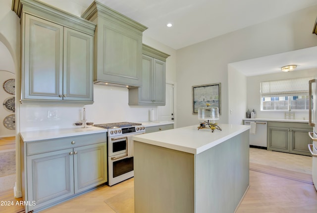 kitchen featuring custom exhaust hood, a kitchen island, light wood-type flooring, and white appliances