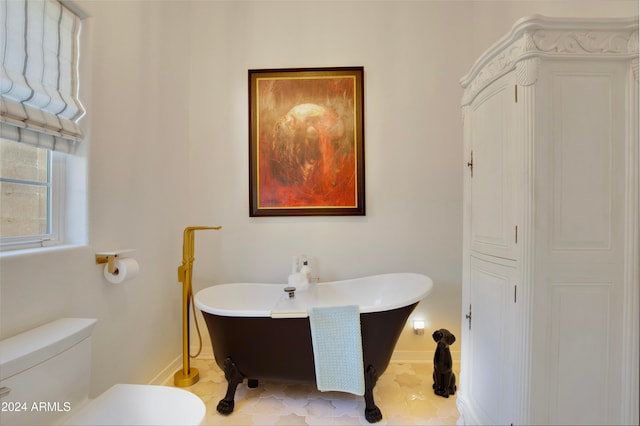 bathroom featuring tile patterned floors, a bath, and toilet