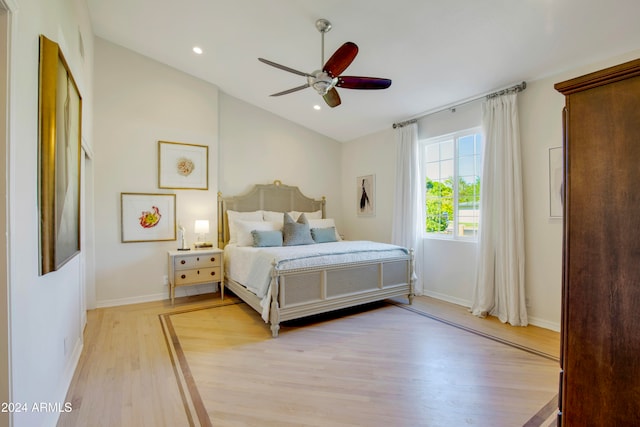 bedroom featuring ceiling fan, vaulted ceiling, and light wood-type flooring