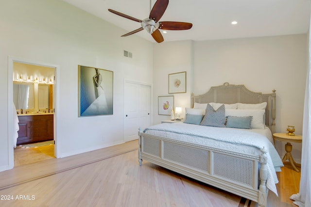 bedroom featuring light wood-type flooring, a closet, ceiling fan, connected bathroom, and high vaulted ceiling