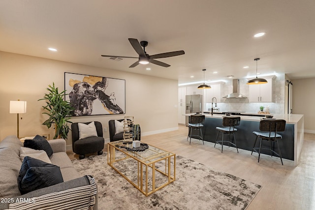 living area featuring recessed lighting, baseboards, visible vents, and light wood finished floors