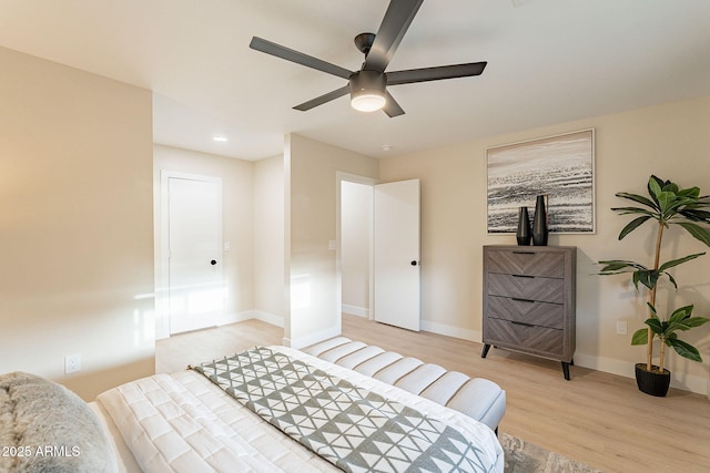 bedroom with a ceiling fan, light wood-style flooring, and baseboards