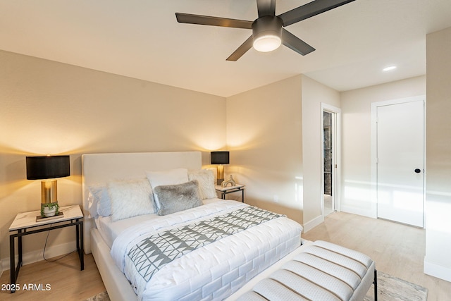 bedroom featuring baseboards, ceiling fan, and light wood-style floors