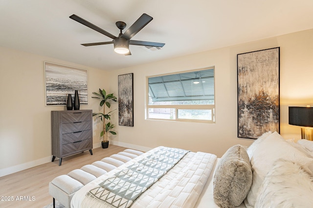 bedroom with ceiling fan, baseboards, and wood finished floors