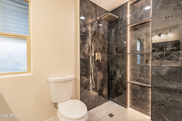 bathroom featuring visible vents, toilet, and a walk in shower