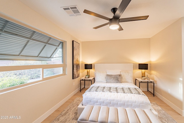 bedroom featuring a ceiling fan, baseboards, visible vents, and light wood finished floors