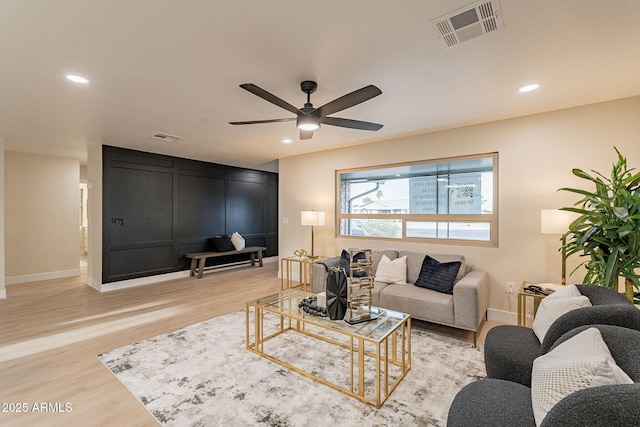 living area with recessed lighting, visible vents, and wood finished floors