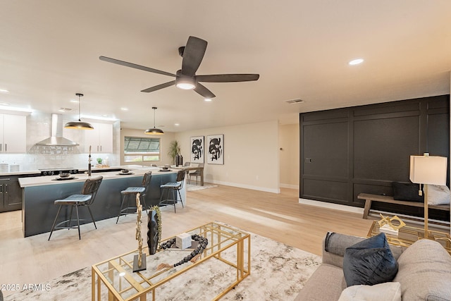 living area featuring ceiling fan, recessed lighting, visible vents, baseboards, and light wood-type flooring