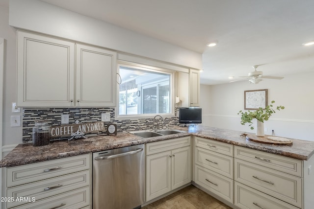 kitchen featuring a peninsula, stainless steel dishwasher, a sink, and tasteful backsplash