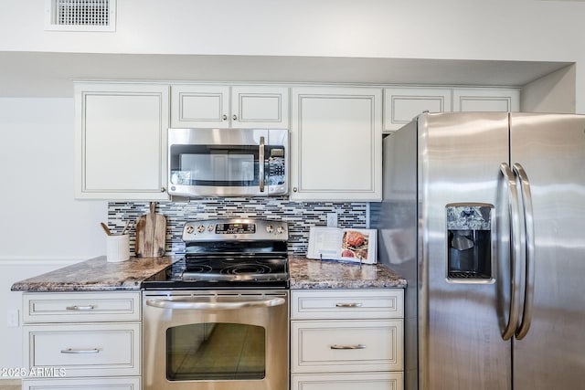 kitchen with stone counters, visible vents, stainless steel appliances, and backsplash