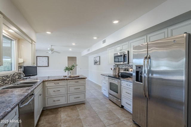 kitchen featuring a peninsula, visible vents, white cabinets, appliances with stainless steel finishes, and decorative backsplash