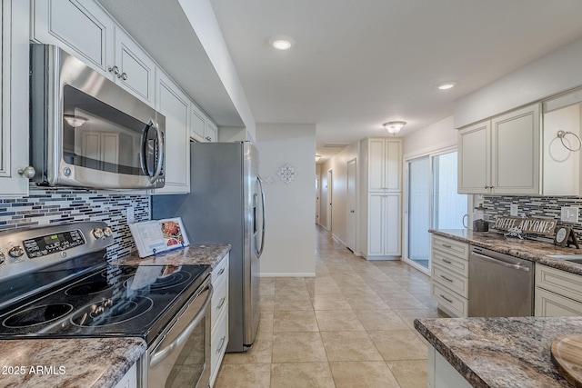 kitchen featuring light tile patterned floors, stainless steel appliances, backsplash, stone countertops, and baseboards