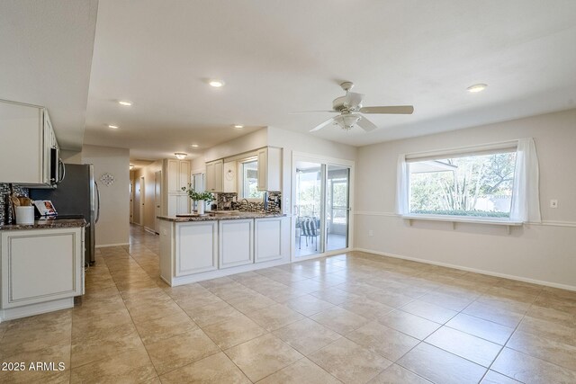 kitchen featuring dark stone countertops, recessed lighting, baseboards, and decorative backsplash