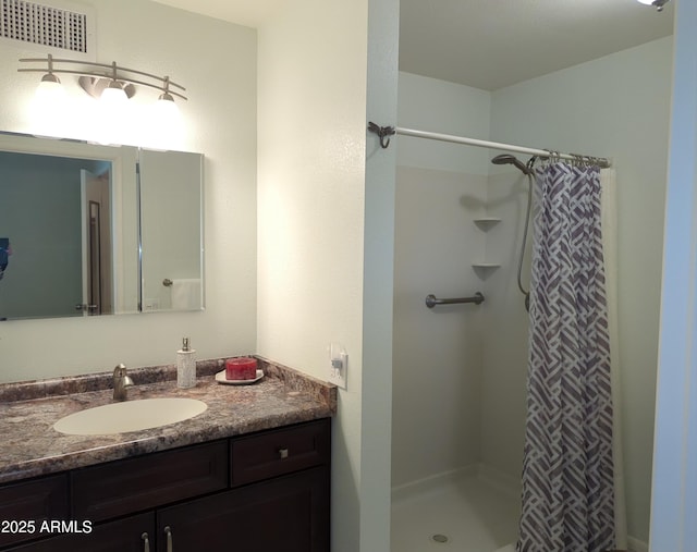 bathroom with a shower stall, visible vents, and vanity