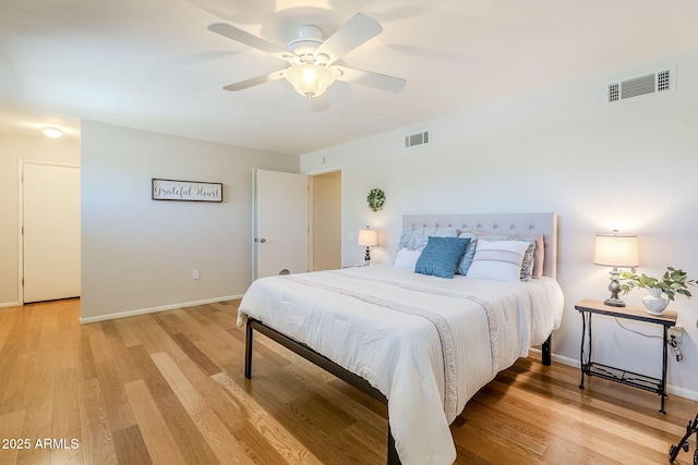 bedroom with light wood finished floors, baseboards, visible vents, and ceiling fan