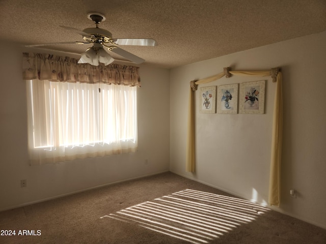 carpeted spare room with ceiling fan and a textured ceiling