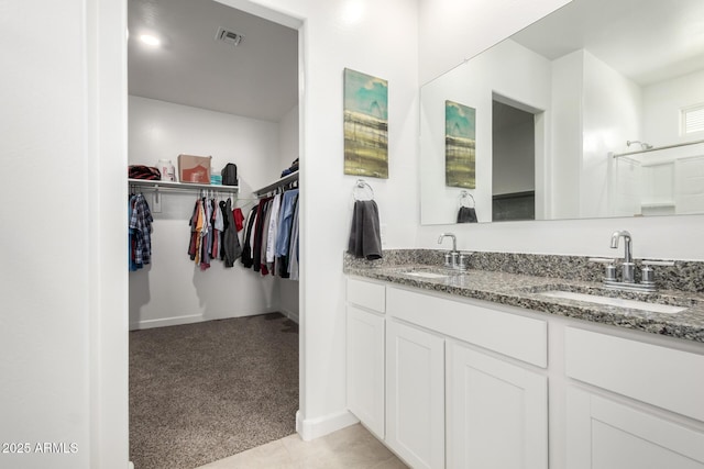 8222 W Clemente Way, Florence, AZ 85132 - bathroom with double vanity, a walk in closet, and tile patterned flooring