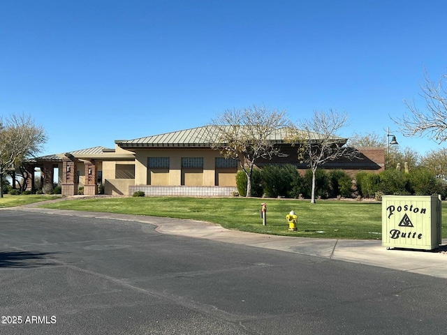 8222 W Clemente Way, Florence, AZ 85132 - view of front of home with stucco siding, a front yard, a standing seam roof, and a metal roof